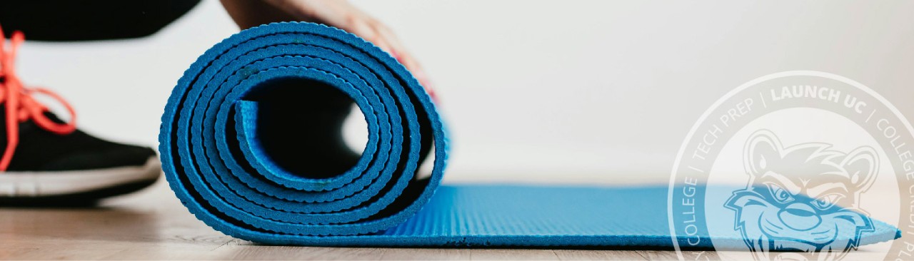 Person rolling up a blue exercise mat