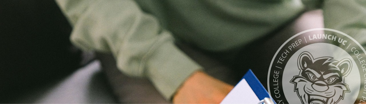 Person sitting and another person holding a clipboard