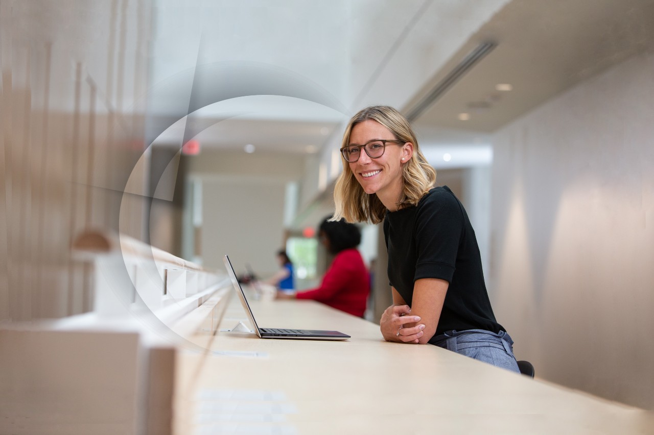 A student in a study area looks up from her laptop