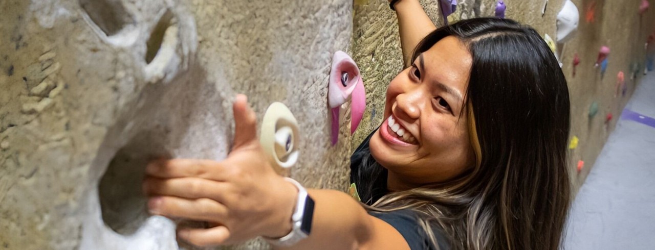 Guests at Campus Recreation Center climbing the climbing wall.