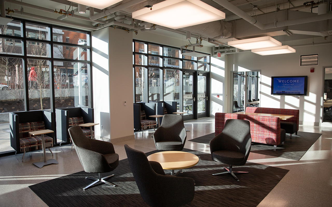 Brightly lit lounge space featuring sofas, chairs and tables