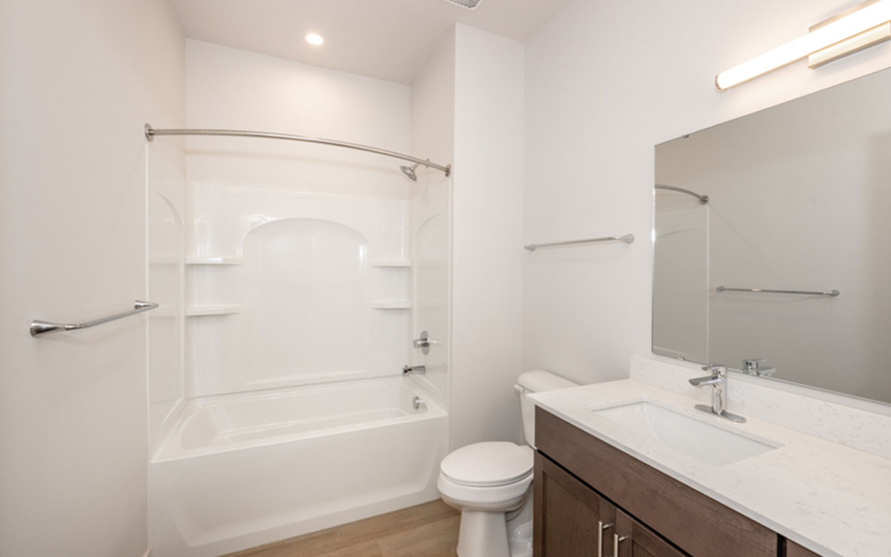 Bathroom with counter/sink, toilet and combination tub and shower