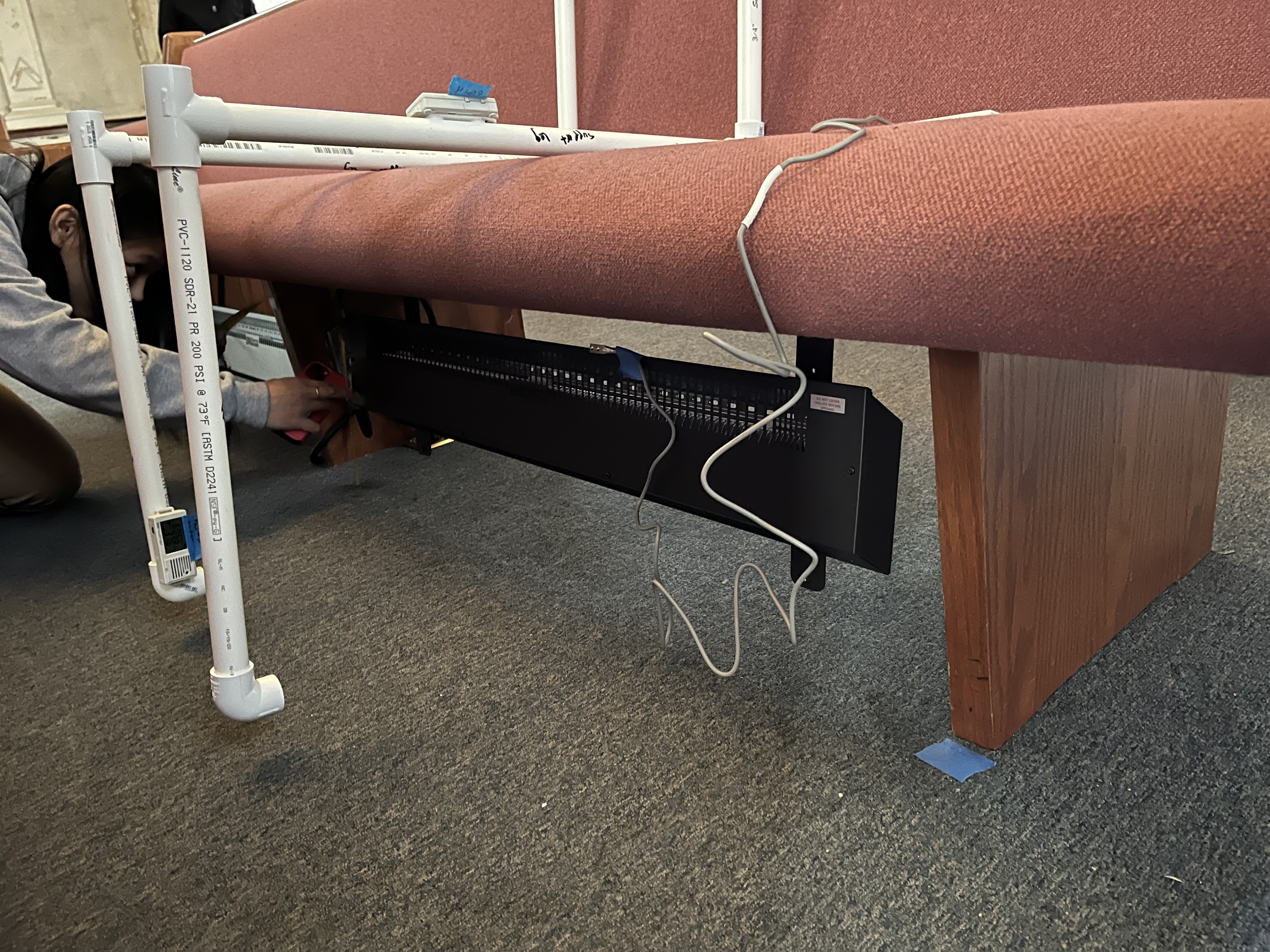 A heater is attached underneath a church pew