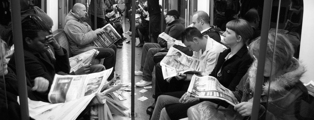 Subway riders read newspapers