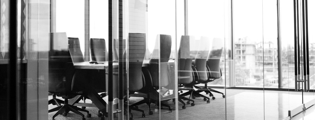 Empty corporate conference room with glass wall in high rise office building.
