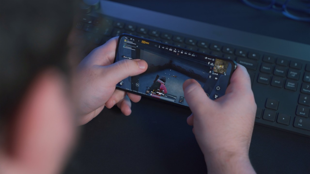 child's hands holding a cell phone with a video game image