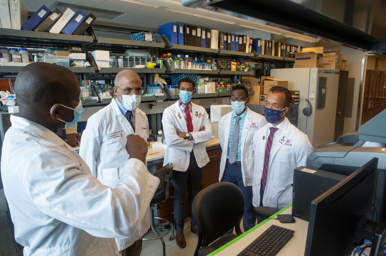Senu Apewokin, MD, and Alvin Crawford, MD, are shown with Austin Thompson and two of his fellow medical students in a lab.