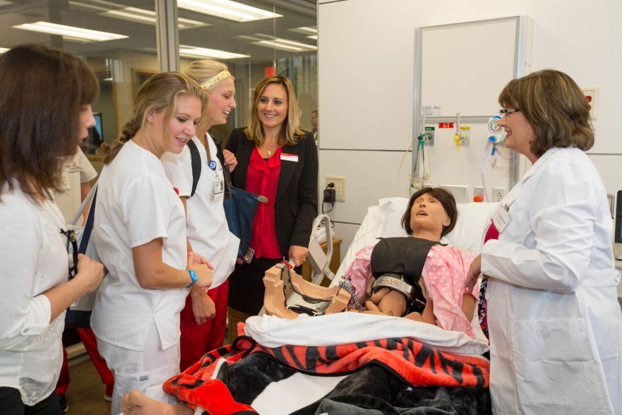 Nursing students and an instructor bedside with a patient mannequin
