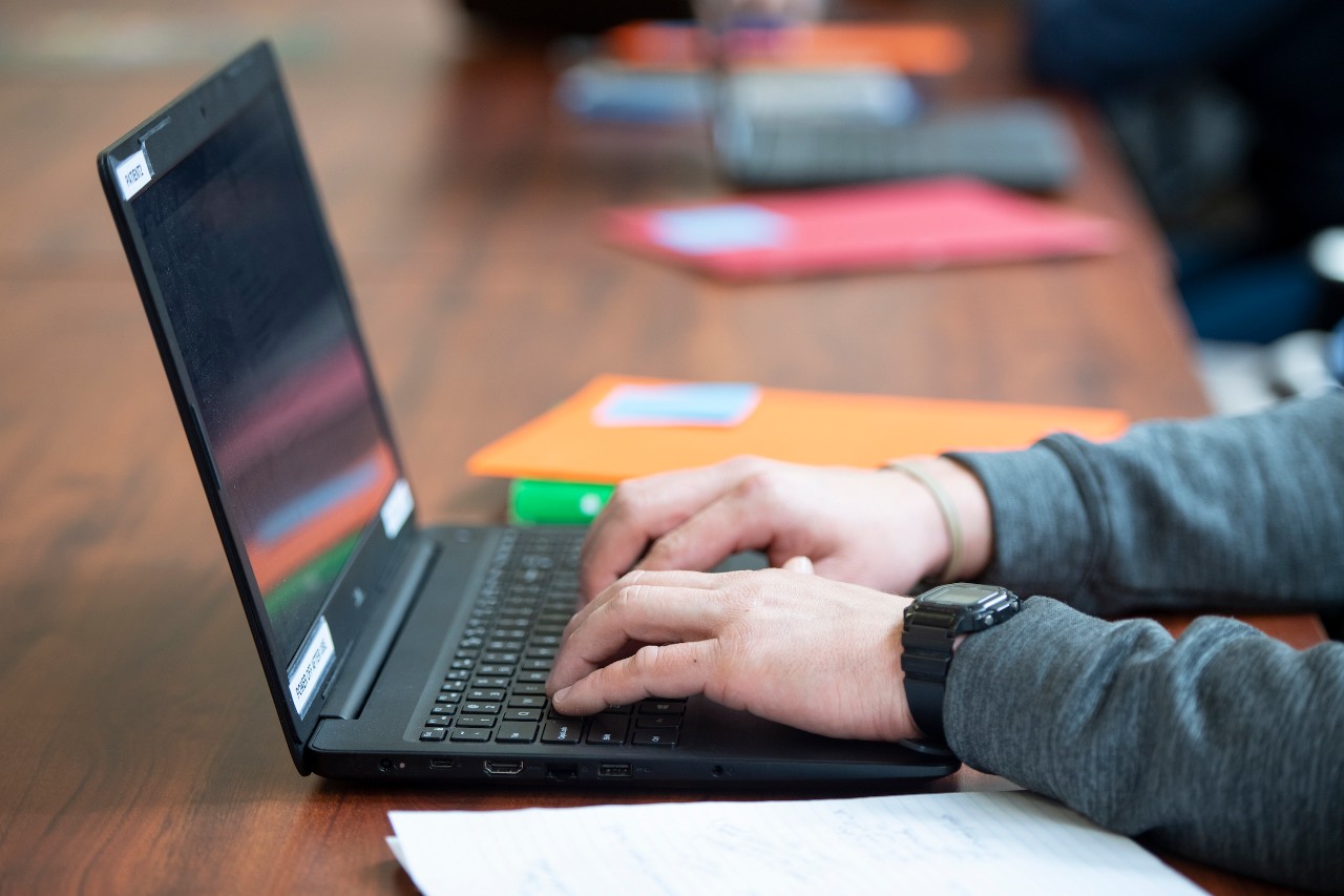 View of person's hands on laptop keyboard