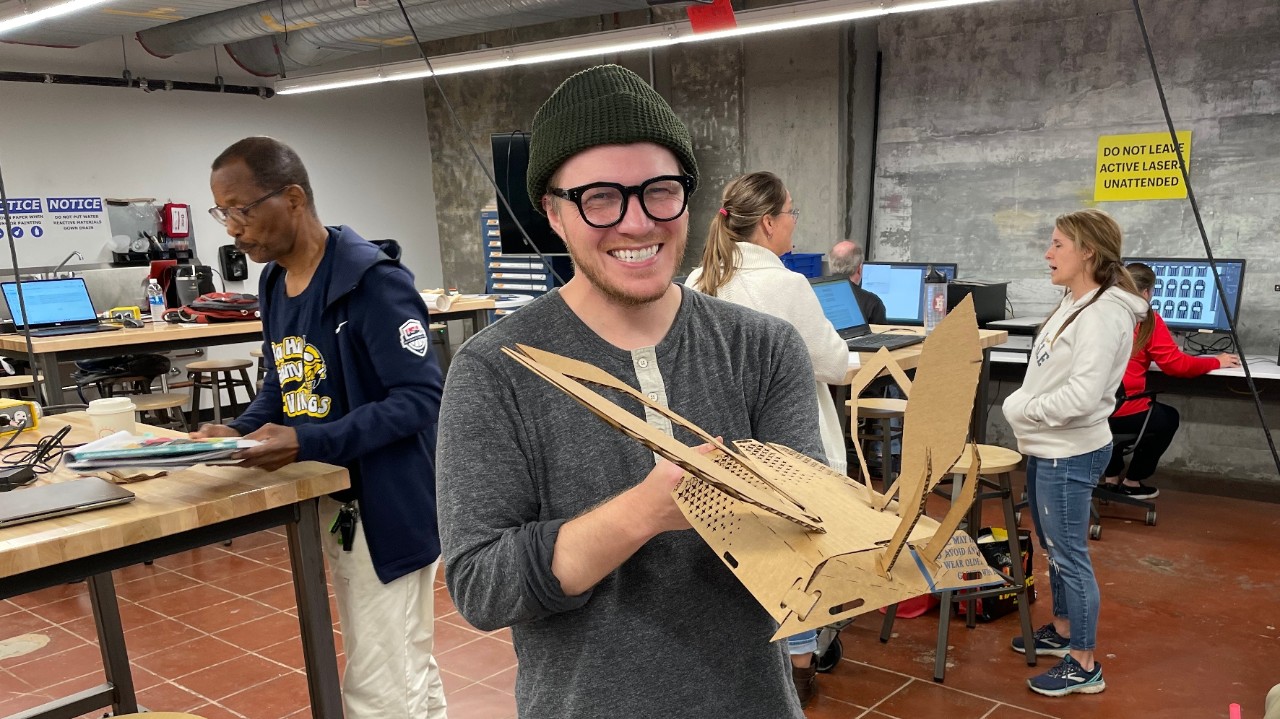 Evan Lewis holds his laser cut firefly in the UC Ground Floor Makerspace.