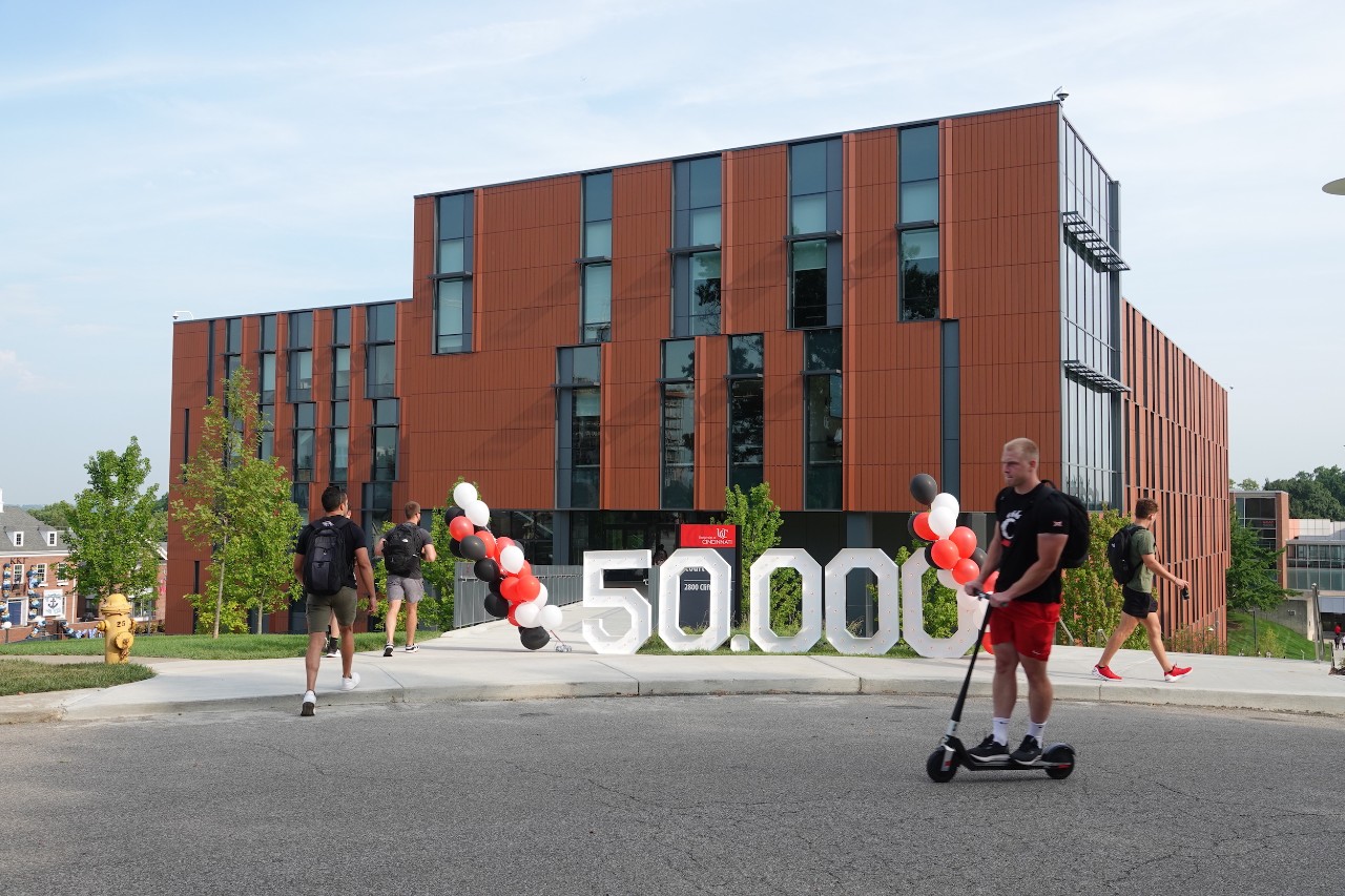 UC students on campus with 50,000 signage