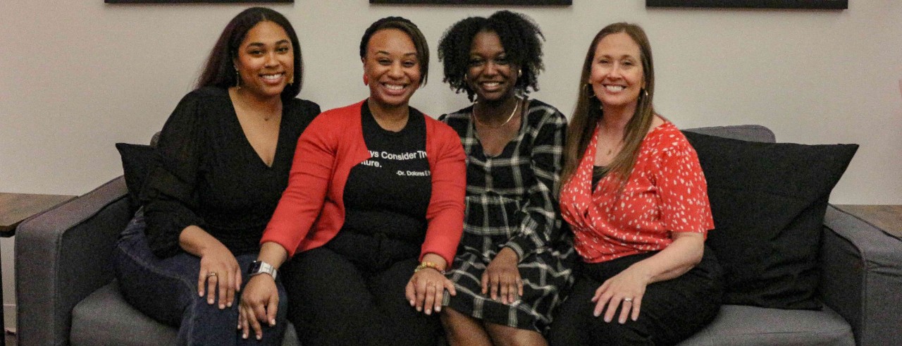 Left to right: Jasmine Robinson, Lauren Prather, Taryn Booker, Amy Hobek sit on the couch in the newly assembled Culture Corner. The signs behind them say "You" "Matter" "Here"