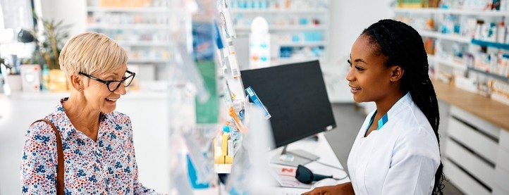 A pharmacist speaks with a customer at the pharmacy counter