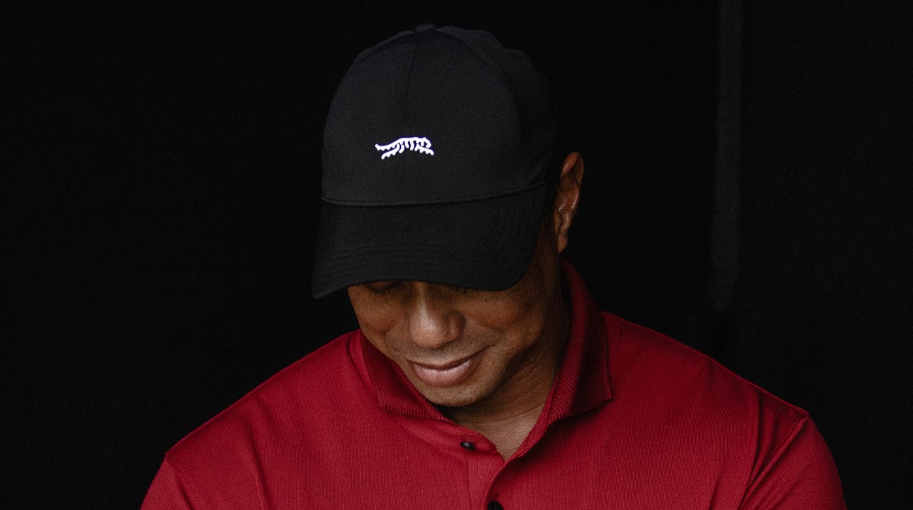 World reknown golfer Tiger Woods in front of his new brand logo: a leaping tiger 