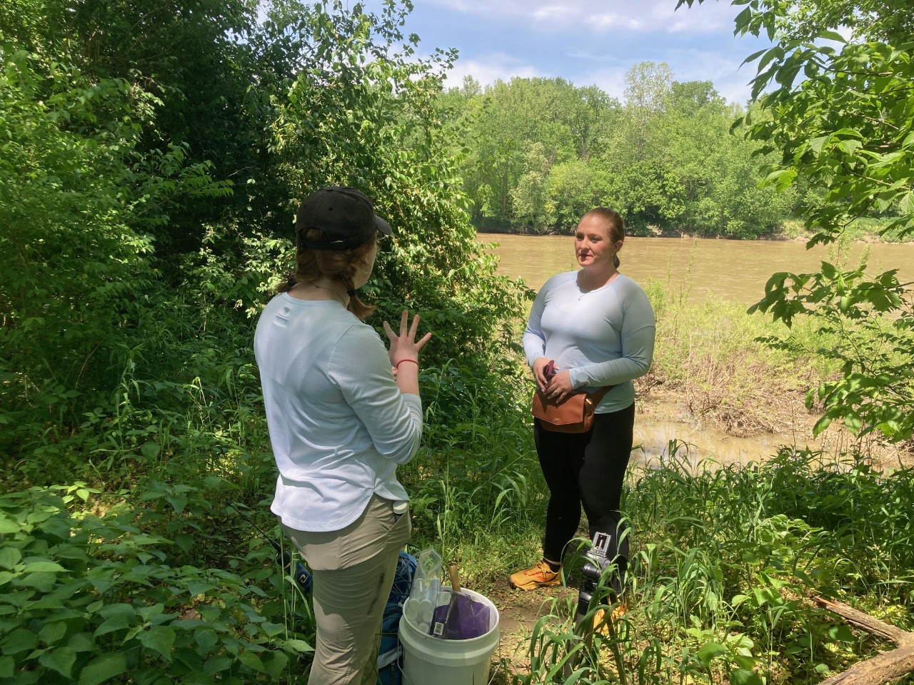 UC doctoral student Megan Naber talks to reporter Alese Underwood on the banks of the Great Miami River.