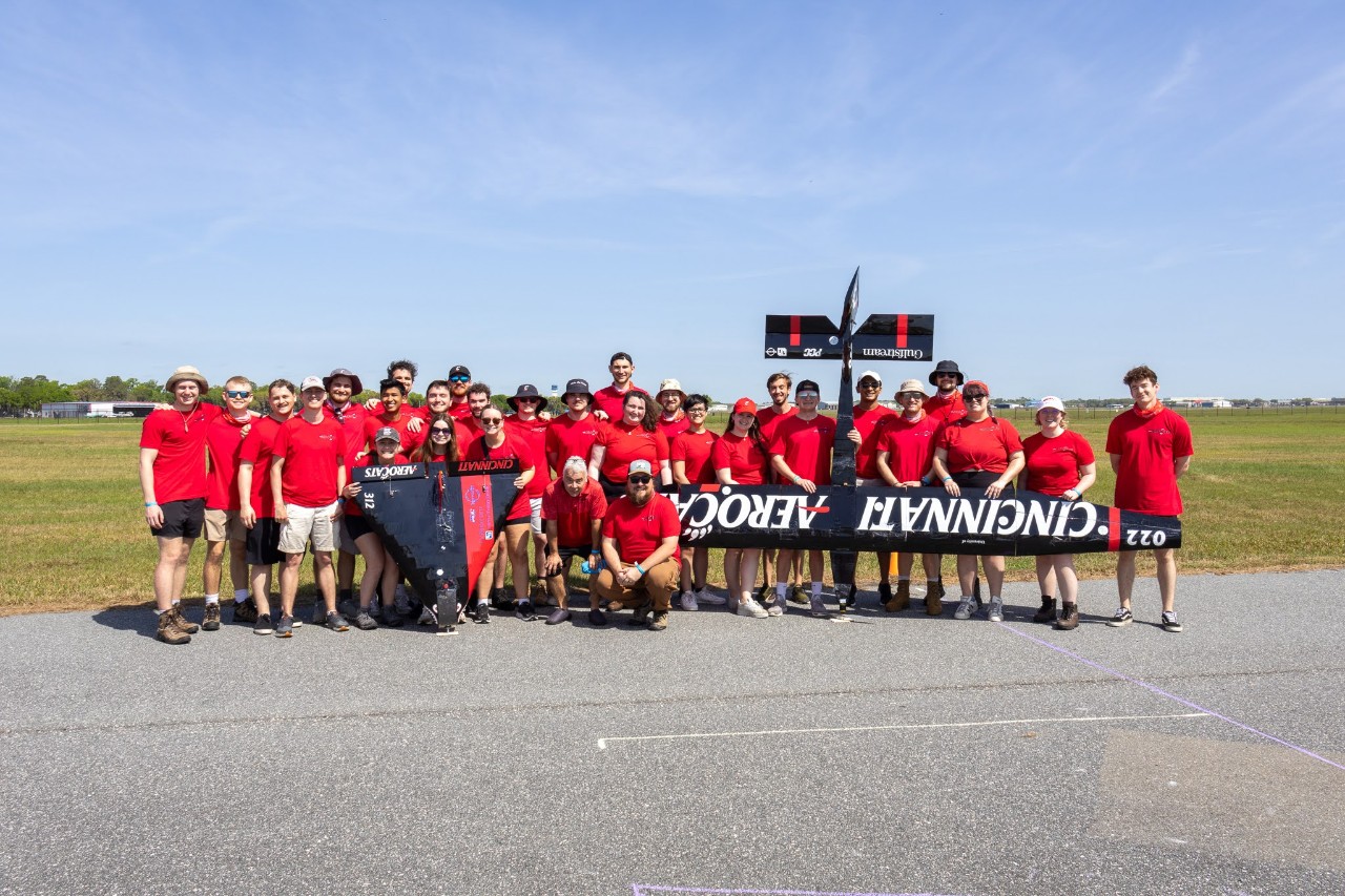 The Aerocats team wearing red t shirts pose with their two aircraft.