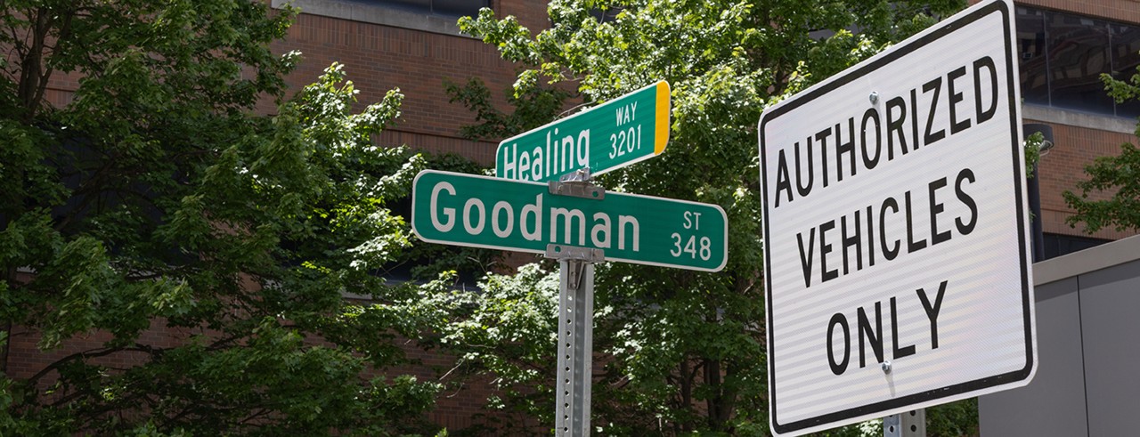 Street signs that say "Healing Avenue" and "Goodman Street" next to another sign that says "Authorized Vehicles Only"