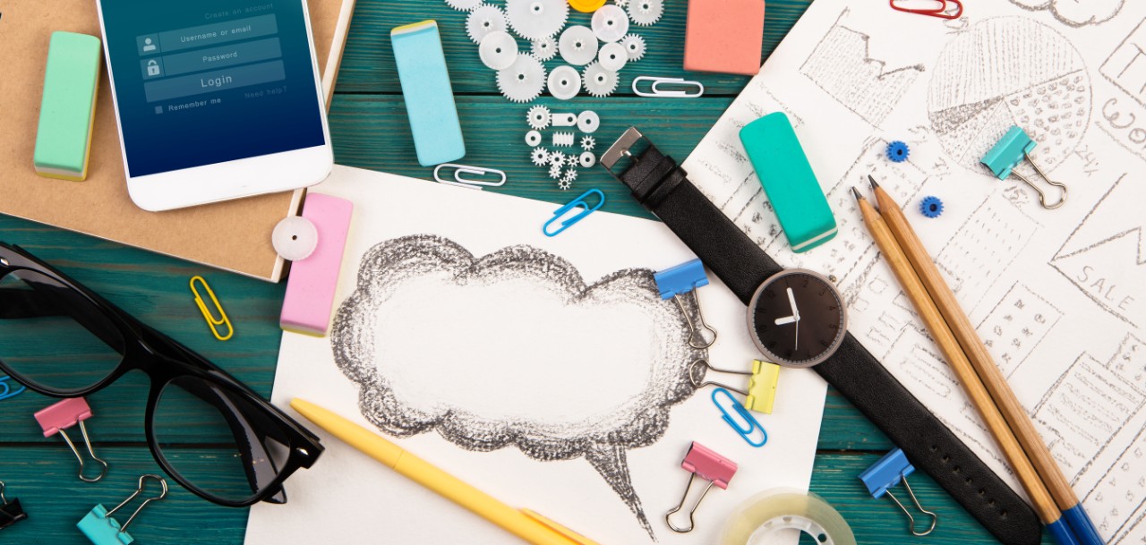 Image of school supplies and cell phone showing log in screen.