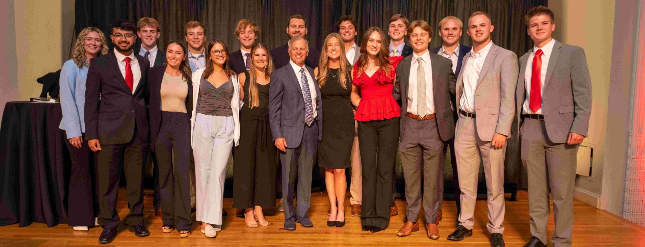 Gregg Fusaro (center, left) poses with Gracie Criger (center, right) and the 16 student scholarship recipients in Cincinnati Music Hall's ballroom