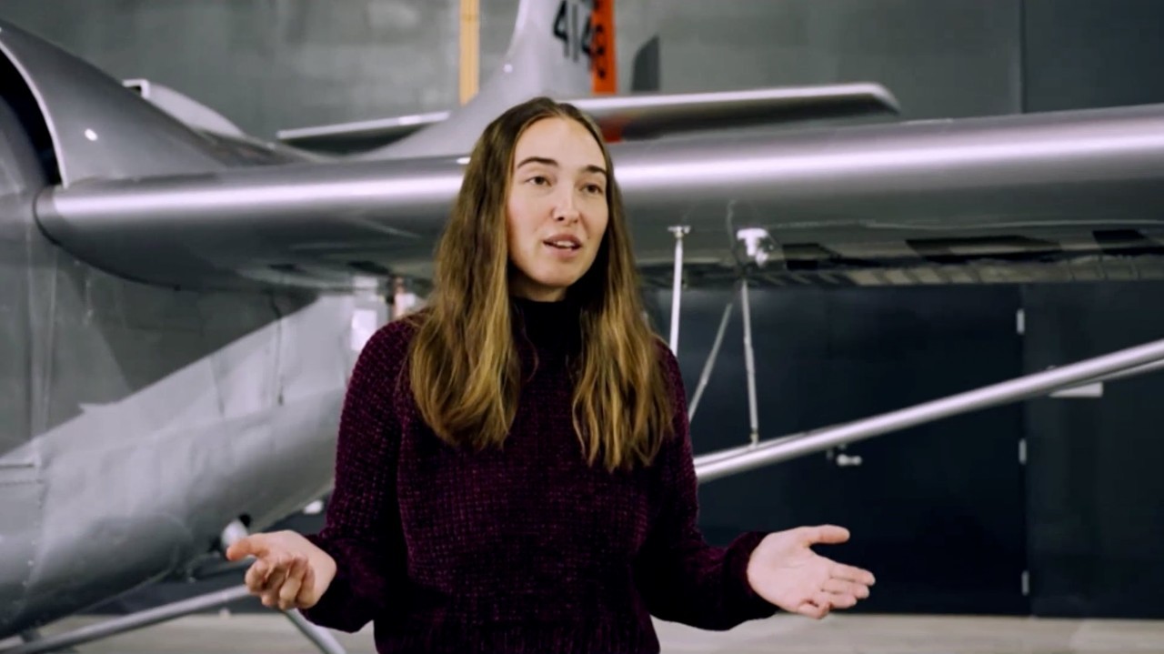 Lynn Pickering stands in front of a plane.