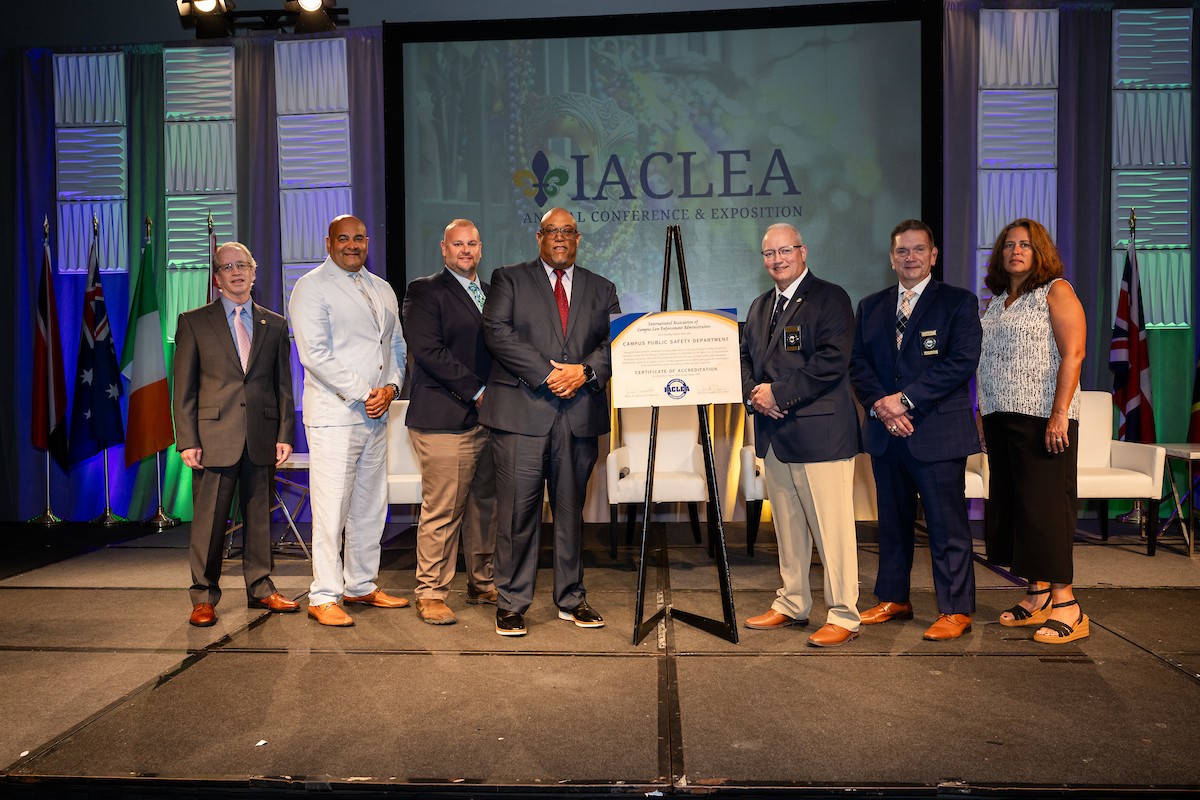 From left, IACLEA Director of Professional Standards Jerry Murphy, UC Police Division Chief of Staff John DeJarnette, UC Assistant Police Chief Dudley Smith, UC Director of Public Safety and Police Chief Eliot Isaac, IACLEA's Immediate Past President Paul Dean, IACLEA Executive Director Paul M. Cell, and UC Public Safety Unit Operations Coordinator Maria Madera pose with a certificate of accreditation during the IACLEA annual conference.