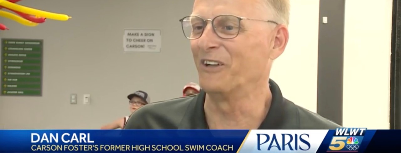 Dan Carl is interviewed at a swimming facility.