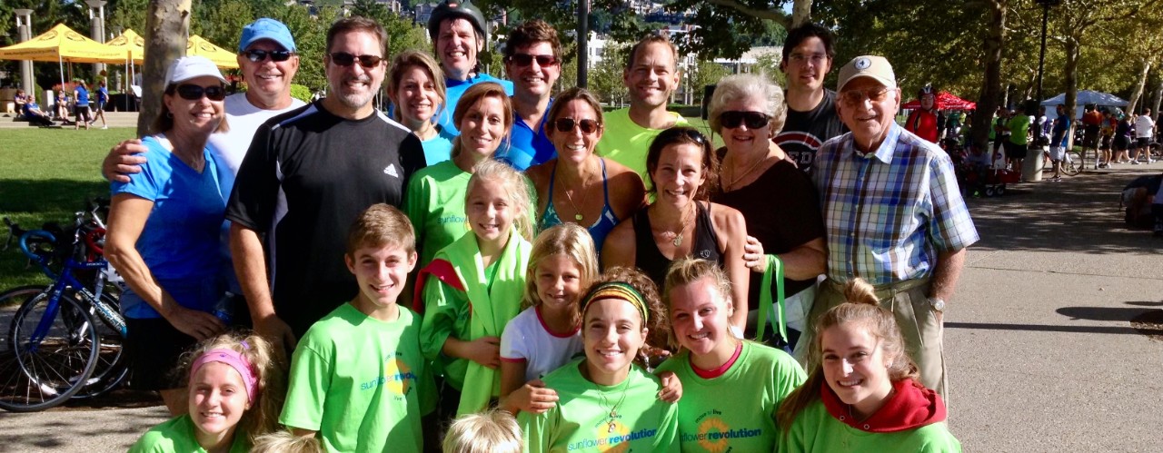 Several members of an extended family wearing matching T-shirts gather together at a Parkinson's fundraising run/walk event at Cincinnati's Sawyer Point.