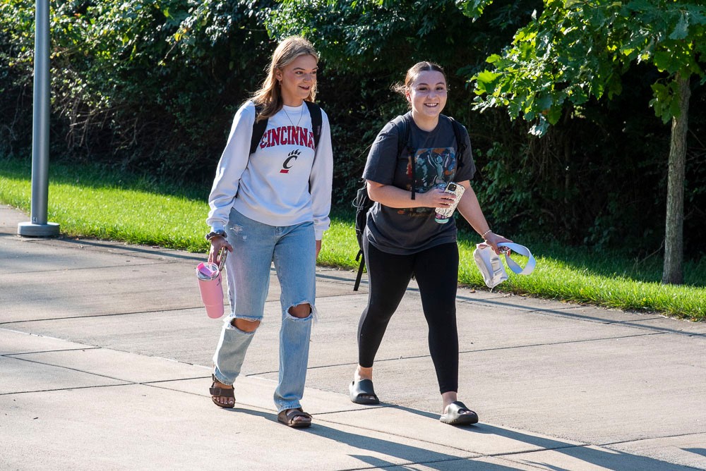 Two students walking outside on the UC Blue Ash campus sidewalk