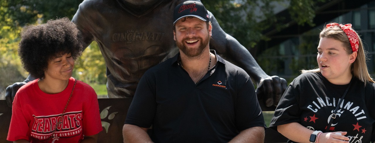 Bengals player Ted Karras poses with students from UC's TAP program