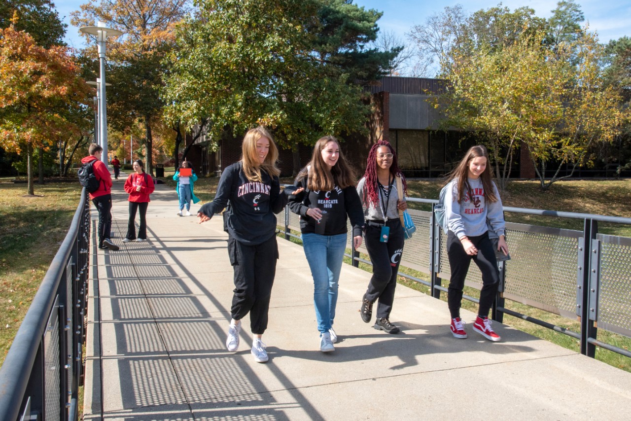 Half a dozen students shown walking on the UC Blue Ash campus