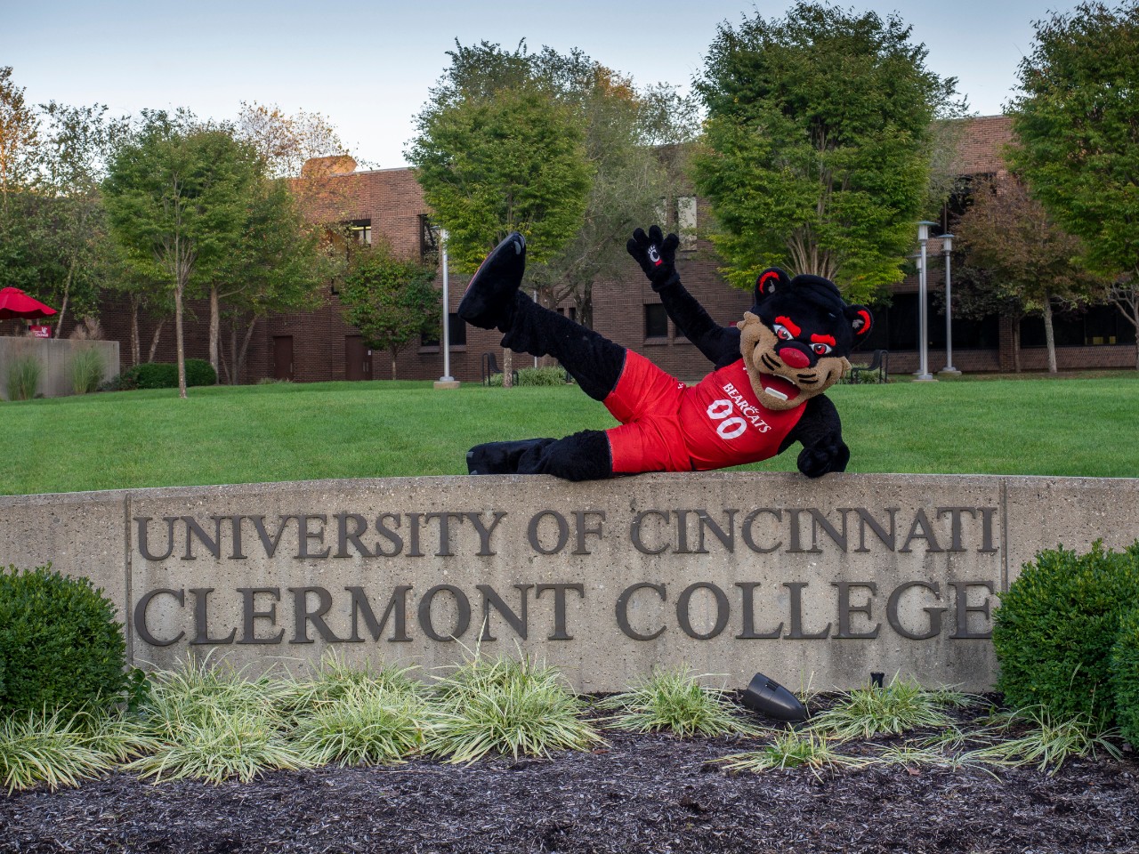 UC Bearcat poses on UC Clermont campus sign