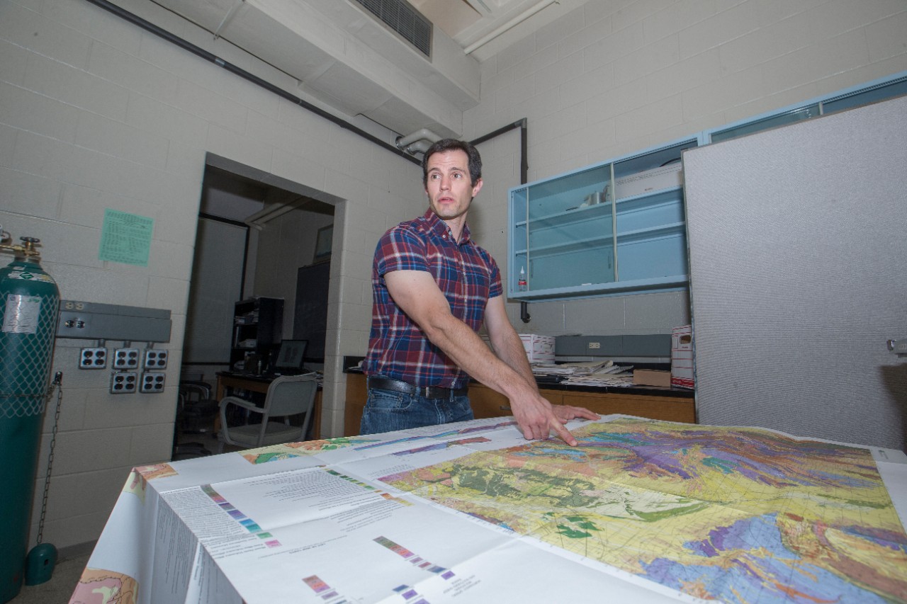 Daniel Sturmer points to a map on a table.