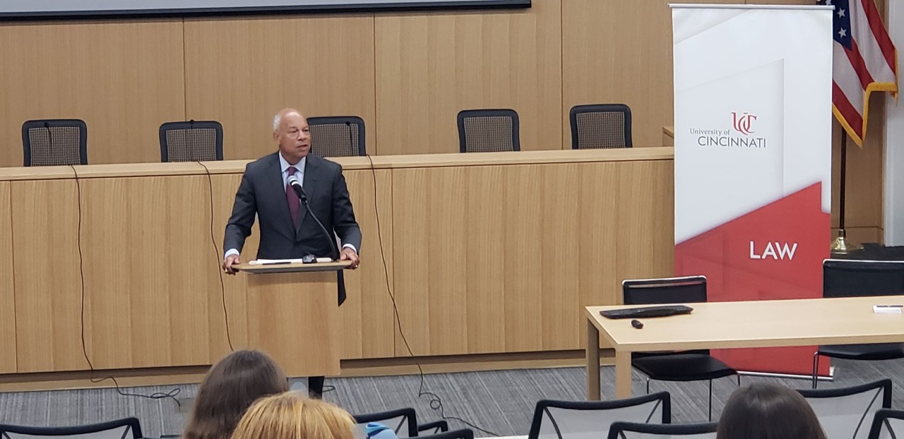 Jeh Johnson stands at podium and addresses UC Law students and faculty