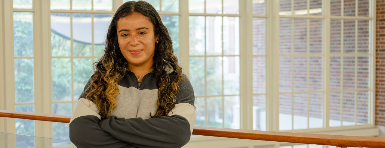 photo of young student Gaby Ramos standing with arms crossed