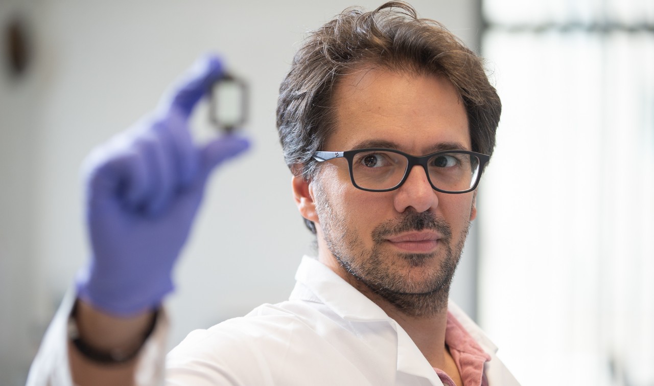 Riccardo Barrile holds up a bioprinted device that mimics a blood vessel in his lab.