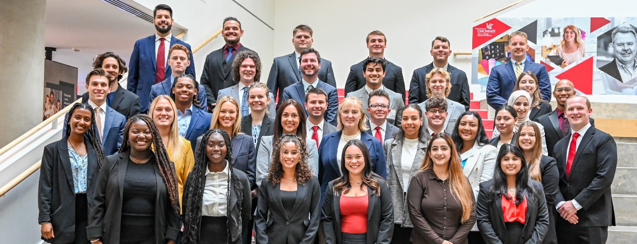 Group photo of the Lindner MBA full-time class of 2025 on the atrium stairs inside of Lindner Hall