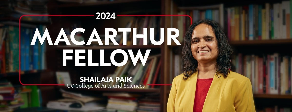 Shailaja Paik standing in front of bookshelves