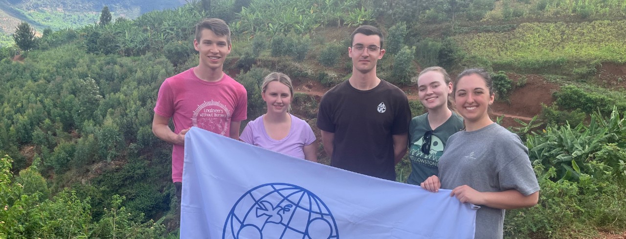 Students hold a white flag that reads "engineers without borders" 