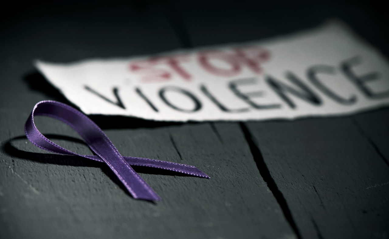 purple ribbon shown with sign saying stop violence