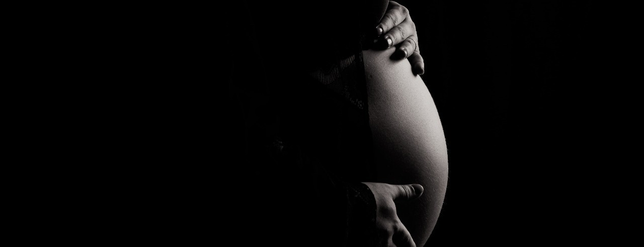 A pregnant woman's belly shown in black and white.