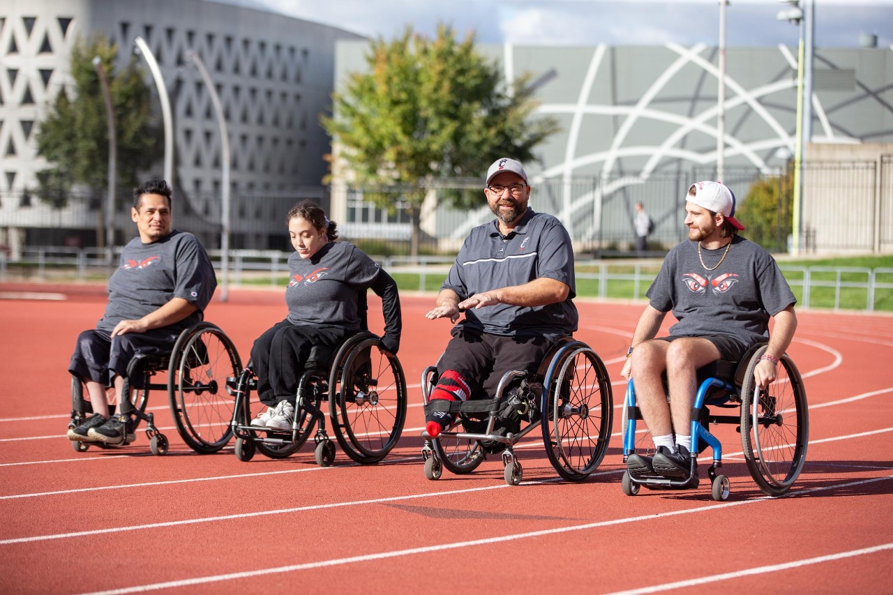 Four people in wheelchairs line up on a track