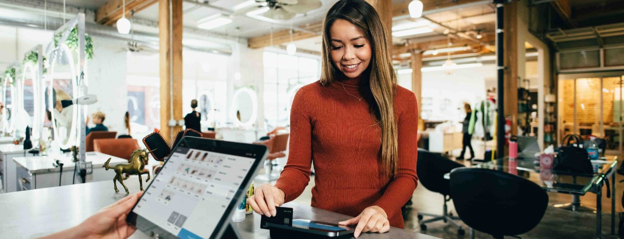 A woman makes a purchase with a credit card.