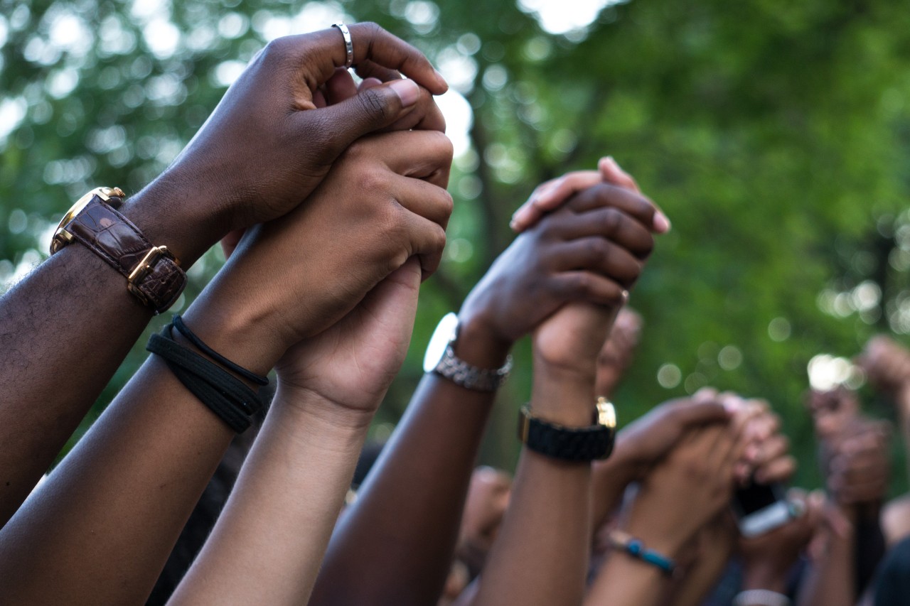 several people raised clutched fists intertwined in show of solidarity