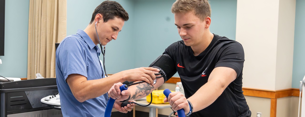 UC assistant professor Matt Chatlaong monitors vitals on an individual during exercise