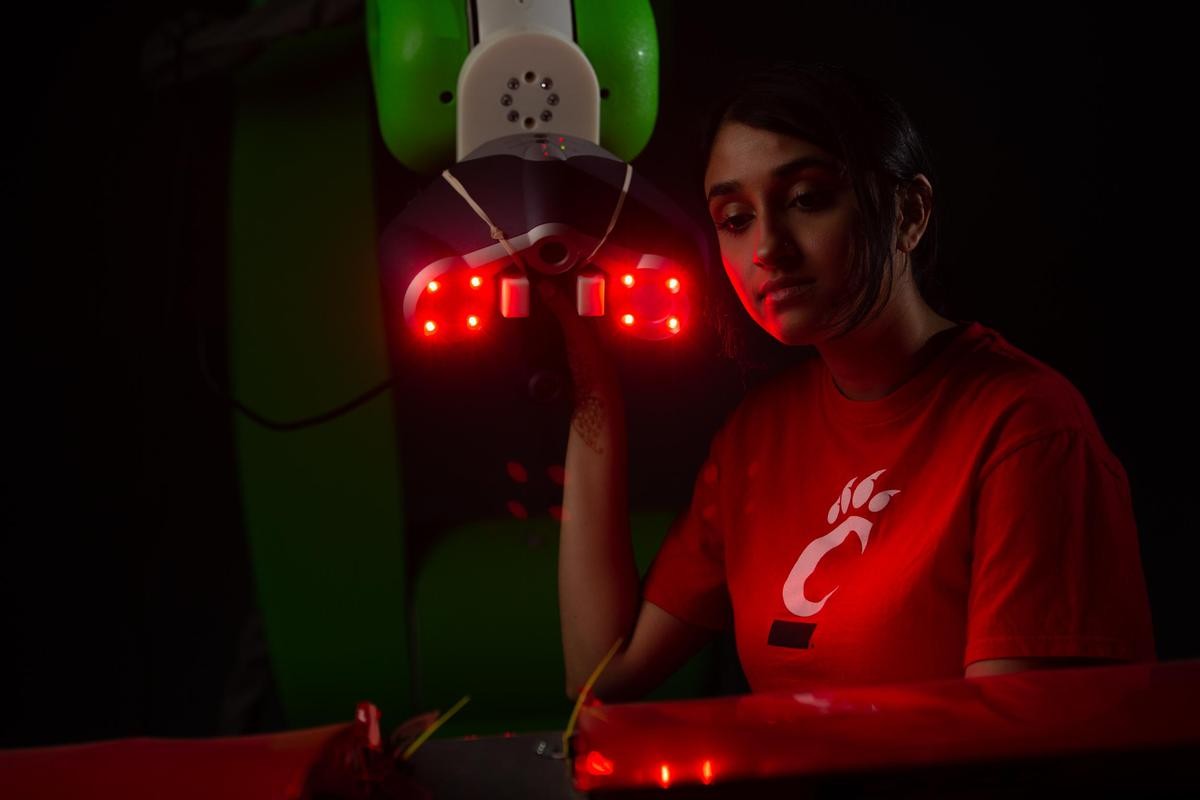 A UC student uses a robotic device fitted with a laser for scanning aircraft.