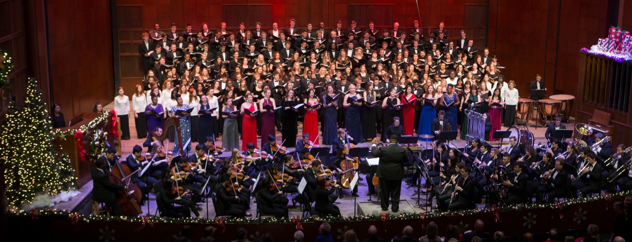 A photo of CCM's combined choirs and orchestra performing on the stage of Corbett Auditorium during the Feast of Carols grand finale. Photo/Andrew Higley