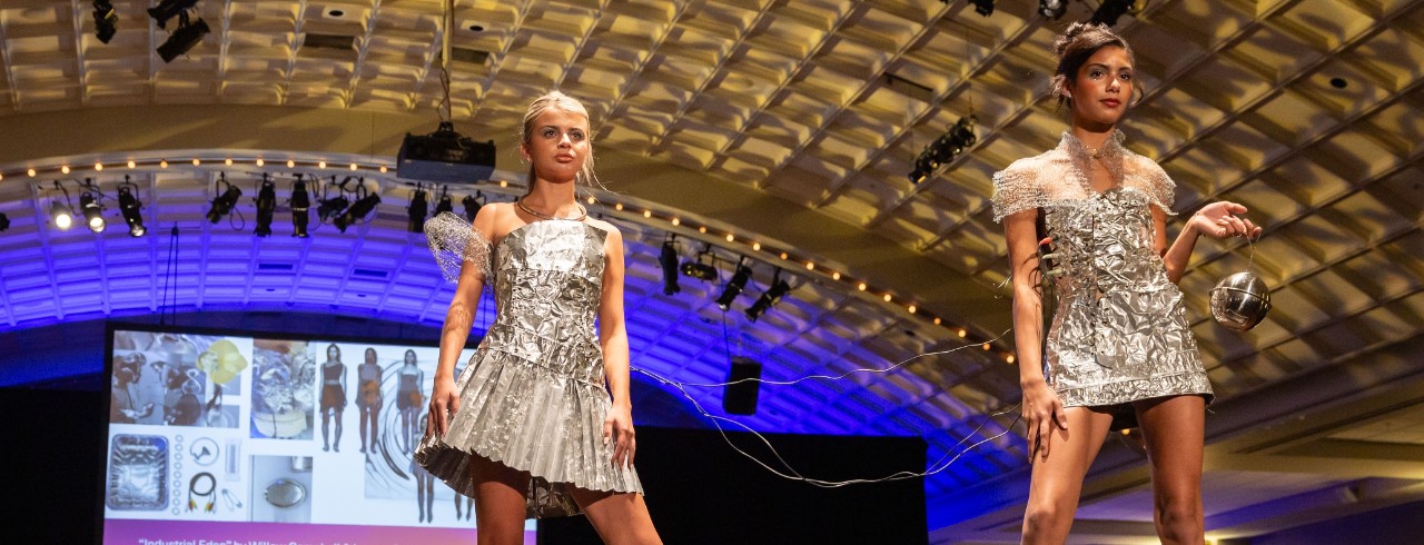 two models wearing dresses made from thrifted metal sheeting