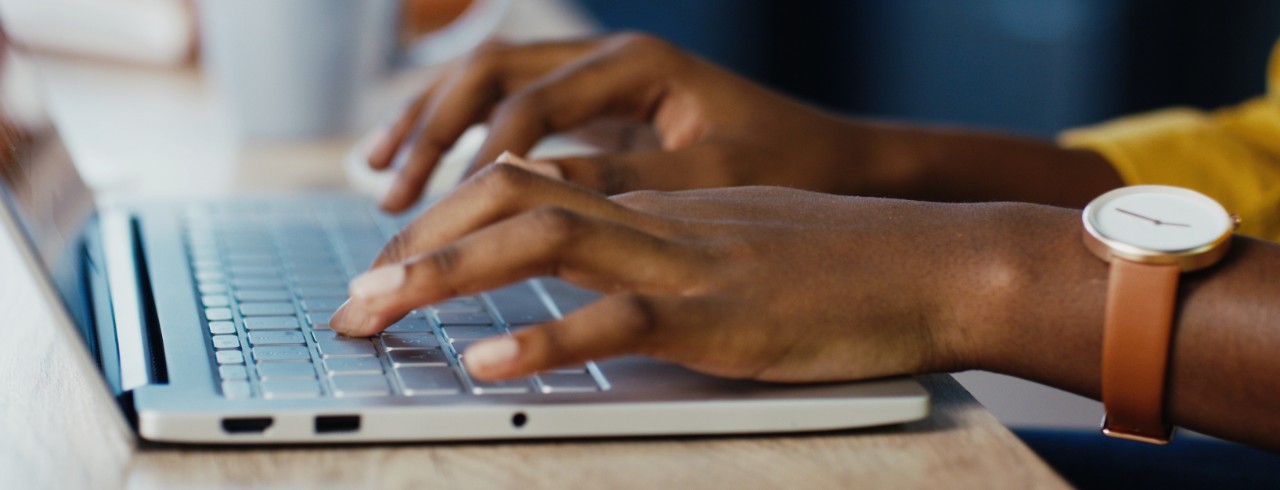 Hands on a laptop keyboard, typing a cover letter