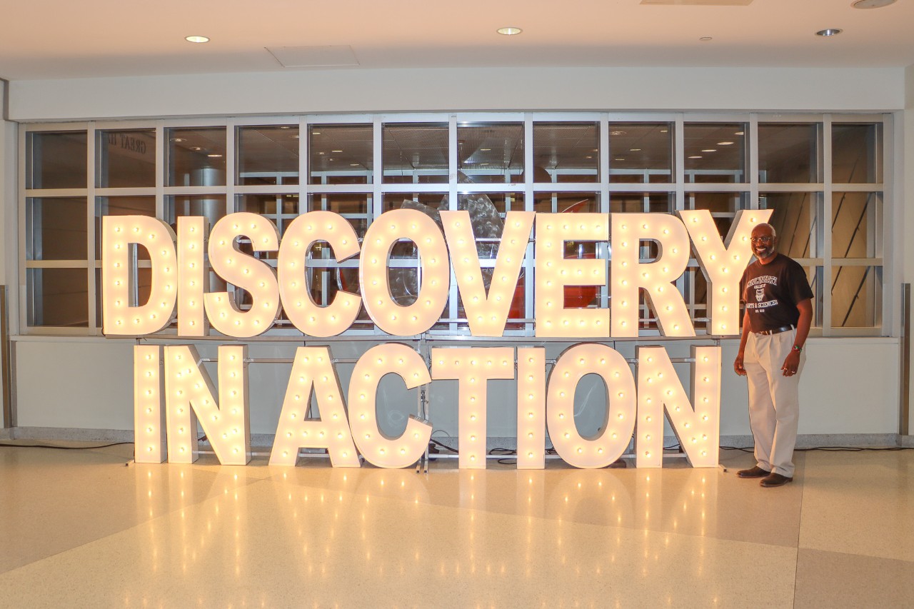 Image of UC Discovery in Action signage with Dean James Mack