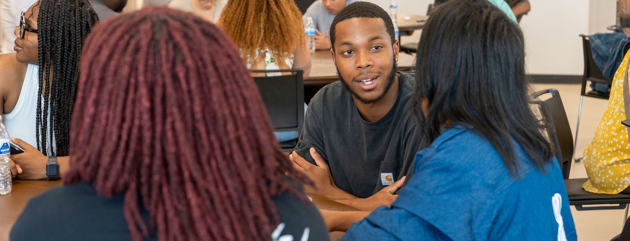 students sit around a table in discussion